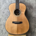 Acoustic guitar on a stand against a textured gray background