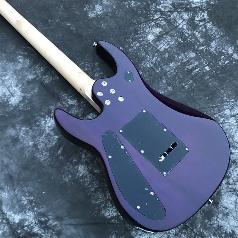 back view of purple electric guitar showing basswood body and cavity covers or a dark grey marble floor.