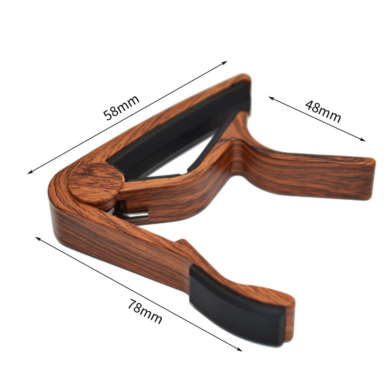 Wooden guitar capo with dimensions labeled on a white background