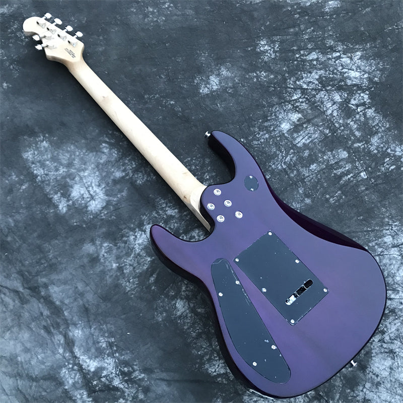 back view of purple electric guitar showing basswood body and cavity covers on  a dark grey marble floor