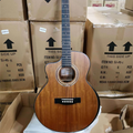 Acoustic guitar in a warehouse setting with stacked cardboard boxes.