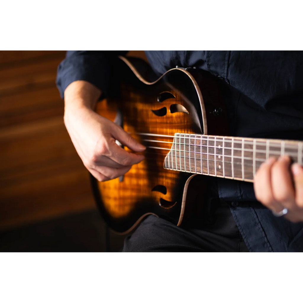 Person playing a electric nylon string guitar with a blurred background