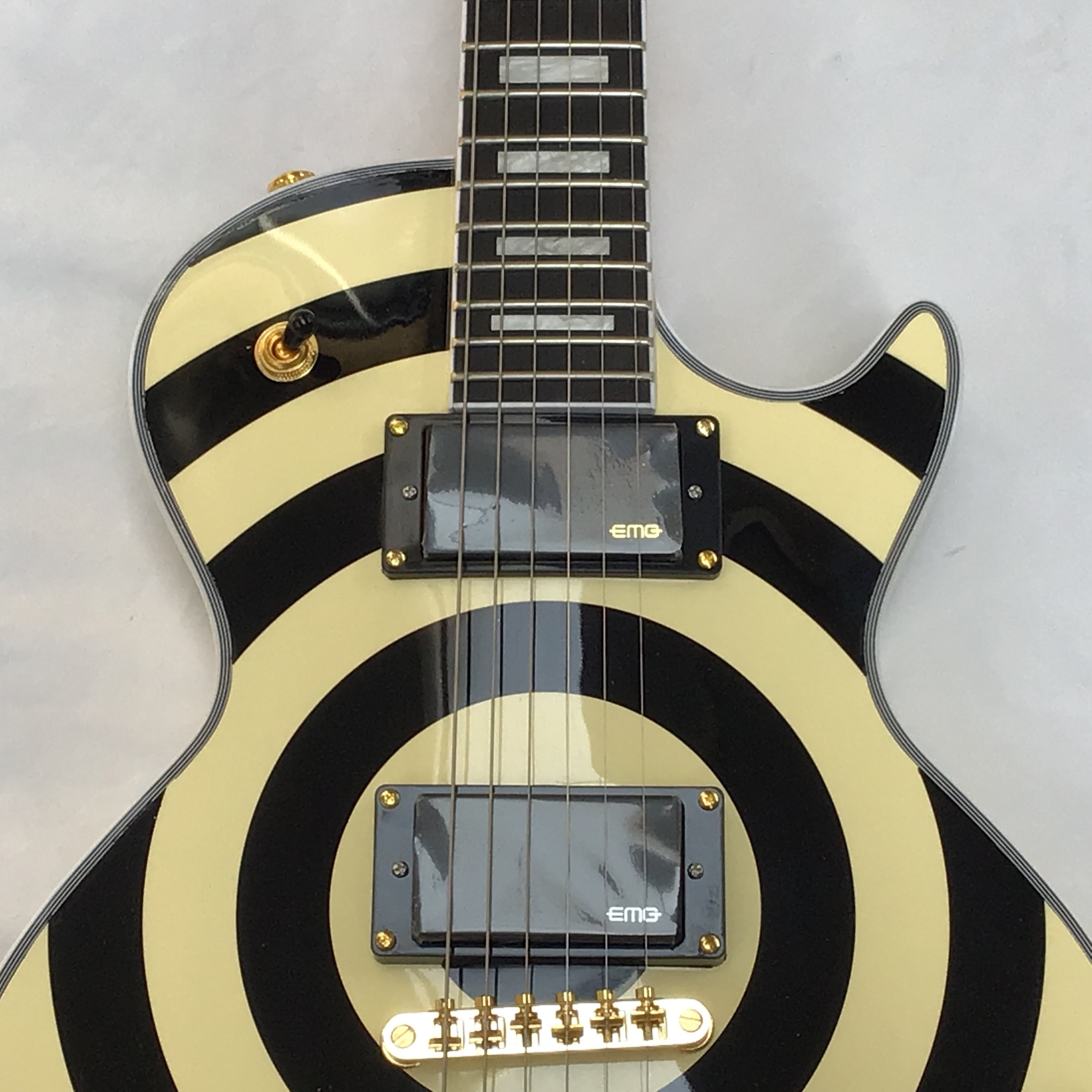 Electric guitar with black and white striped design on a gray background