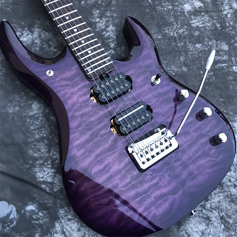 Purple premium modern style electric guitar with a cable on a textured gray marble surface