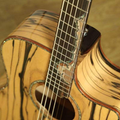 Close-up of a wooden acoustic guitar with a focus on the neck and soundhole. shows the high end quality of a premium solid sandalwood acoustic gutiars australia