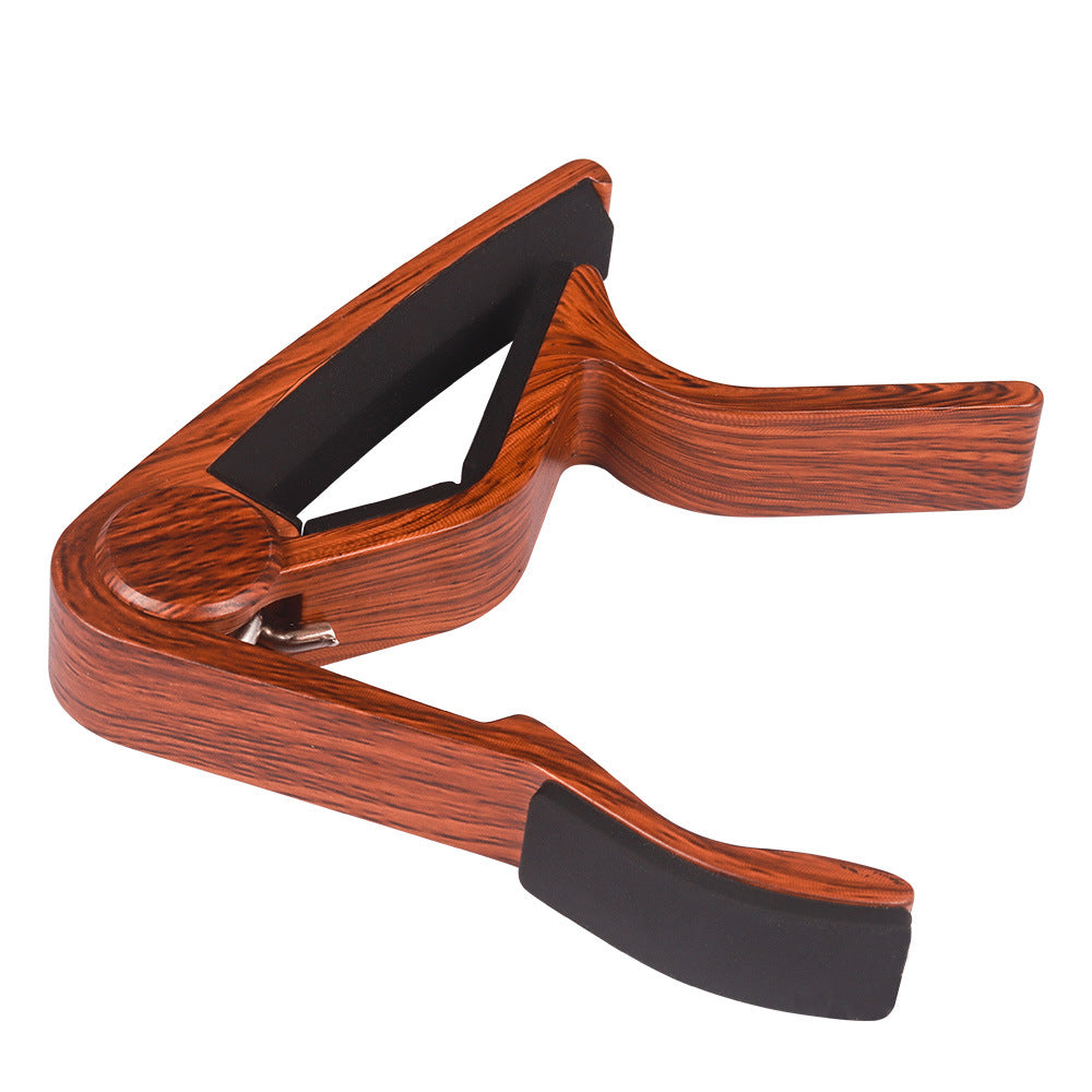 Wooden guitar capo on a white background