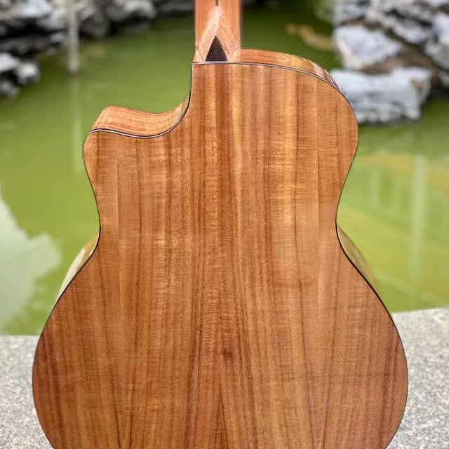 Close-up of a wooden acoustic guitar with a natural finish, outdoors. Sydney guitars onlines provides custom hand-crafted guitars online