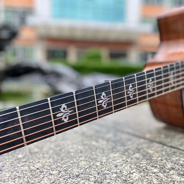 Close-up of a guitar neck with a blurred outdoor background